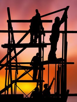 Silhouette of construction workers on scaffold working against a vivid and colorful sunset