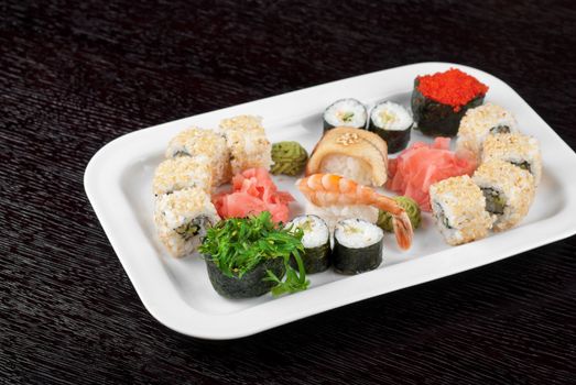 japanese sushi set and sushi with green seaweed closeup in the foreground