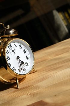 Nice alarm clock closeup standing on wooden surface