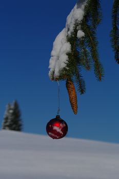 red bauble christmas ball ornament outside in a snowy winter scene