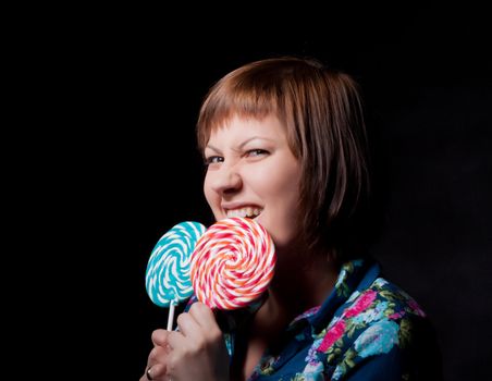 young woman with lollipop, black background