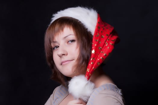 young woman in christmas cap, black background
