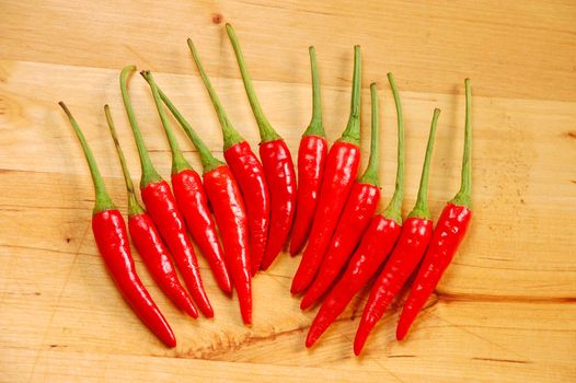 Red chili peppers on wooden cutting board