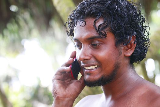 Portrait young men with phone on a green background. Sri Lanka