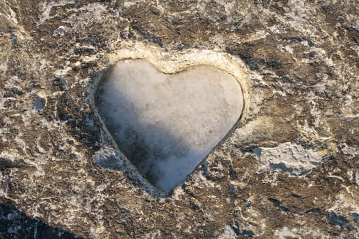 Heart carved on a stone surface. Close-up.