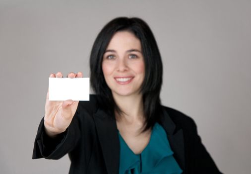 Smiling woman showing a business card with copy space. Focus on the card.