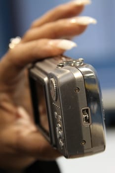 Close up of woman's hand holding digital camera.