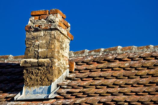 Old brick chimney and roof top with bright sky background