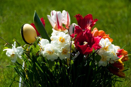 Bouquet of spring flowers (daffodils and tulips) with Easter eggs
