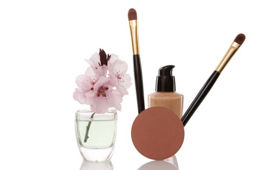 cosmetics and cherry flower on white background