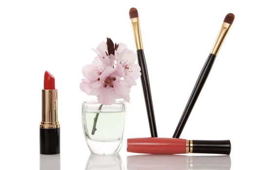 cosmetics and cherry flower on white background