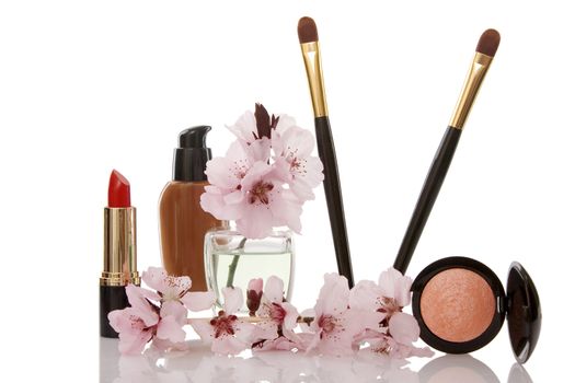 cosmetics and cherry flower on white background