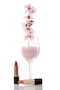 red lipsticks and cherry flower on white background