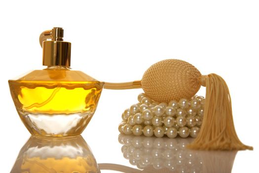 Perfume in a glass bottle and pearl beeds on white background