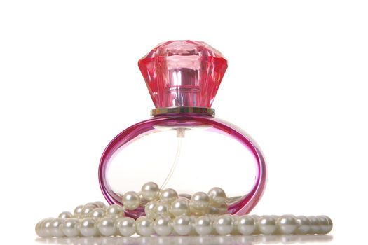 Perfume in a glass bottle and pearl beeds on white background