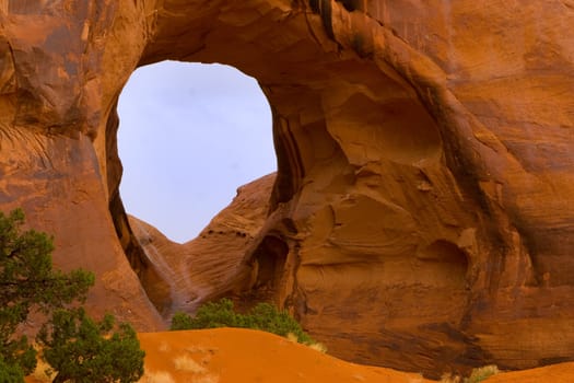 A wind cave in Monument Valley, showing the sparse vegetation in this arid land