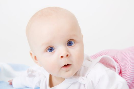 baby girl lying on a white background
