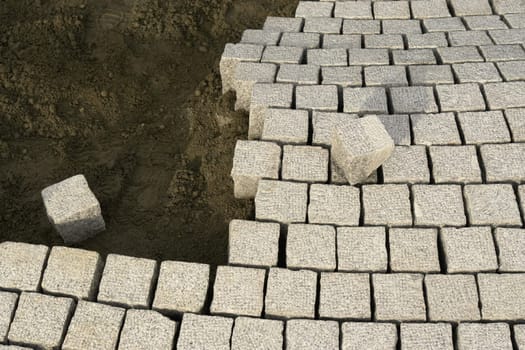 roadworks with cobblestones at a building site..