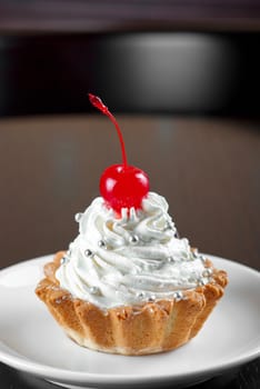 fresh baked cherry cupcake on a dark wooden background