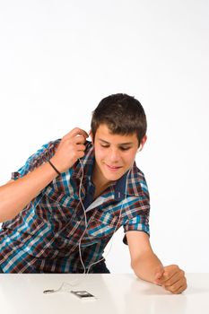 Teen enjoying his MP3 player, isolated on white