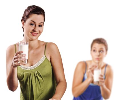 Beautiful young women drinking a healthy glass of milk - on white background with space for text