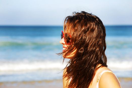 Pretty girl with hair blowing in the wind on the beach
