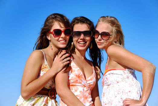 Three young woman having fun on the beach on a summer day