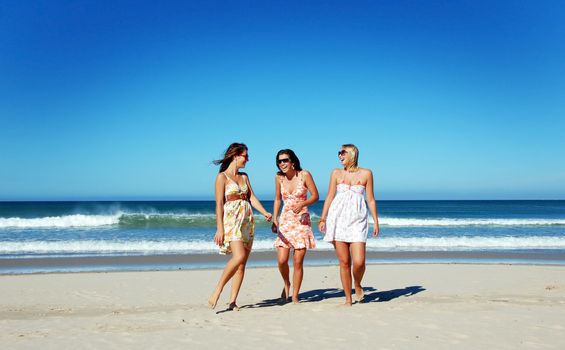 Three young woman having fun on the beach on a summer day