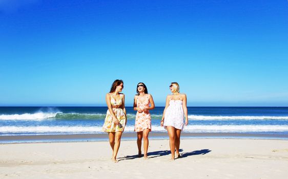 Three young woman having fun on the beach on a summer day