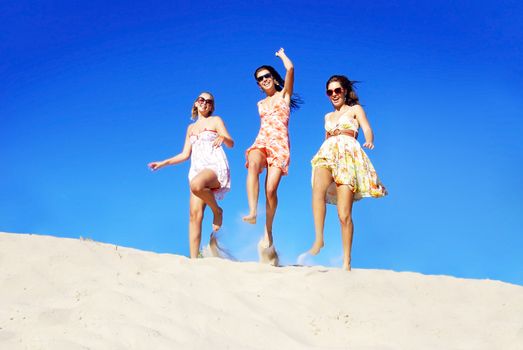 Three young woman having fun on the beach on a summer day