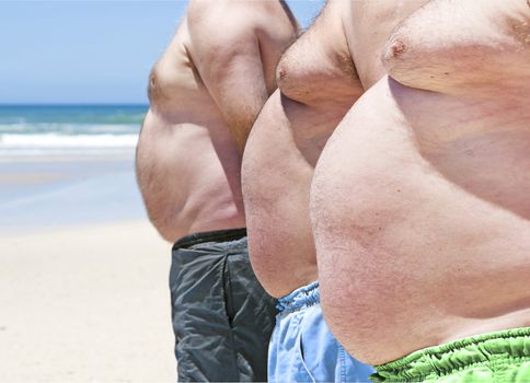 Close up of three obese fat men of the beach