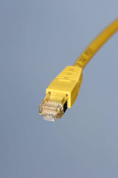 Yellow network cable against blue sky background