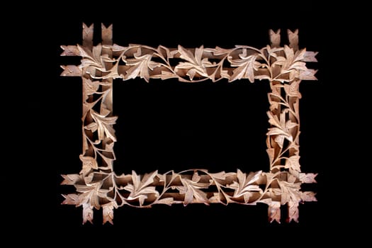 A wooden floral frame, isolated on a black background.