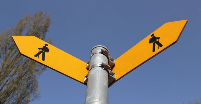Yellow sign showing two differents ways the way to walkers and blue background