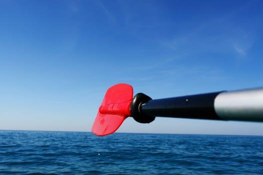close-up of a red paddle outside in the ocean