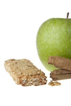 Granny smith apple, cinnamon sticks and apple cinnamon granola bar.