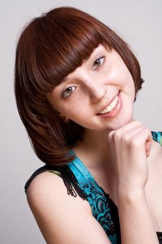 laughing girl in a dress on a gray background