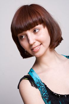 laughing girl in a dress on a gray background