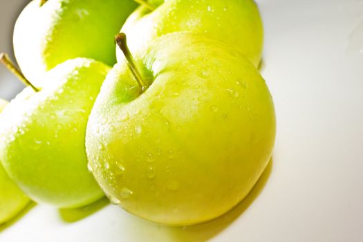 Green apples with water isolated on white