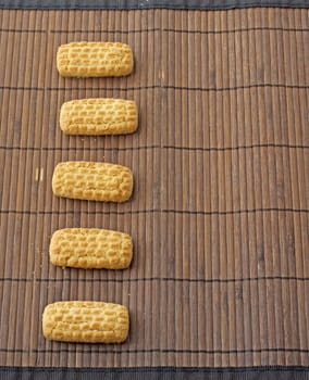 Five long biscuits over a wooden dark mat