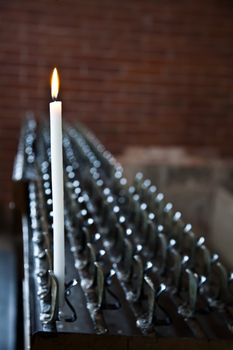 Lonely candle in a Italian Abbey. Concept of hope, faith, loneliness