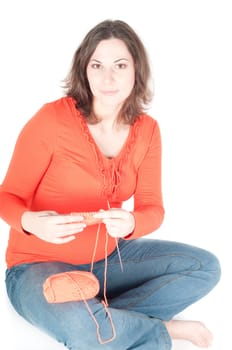 Portrait of pretty pregnant woman knitting, isolated on white