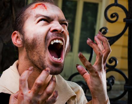 Close-up of wounded male vampire roaring, looking up