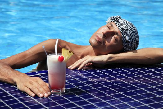 The man with a cocktail in pool