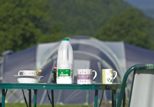 Picnic table laid for breakfast on a camping holiday