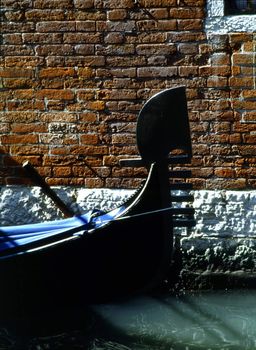 Gondola by a wall in Venice