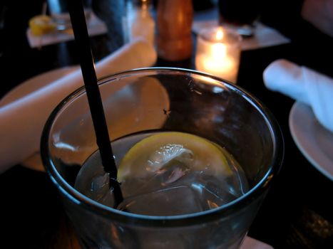 A closeup of a glass of water with lemon at a restaurant - waiting to be served. 