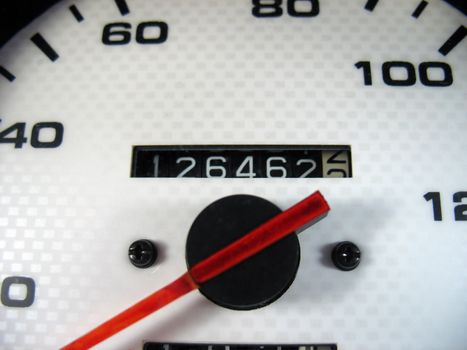 A macro shot of a speedometer & odometer from a car.