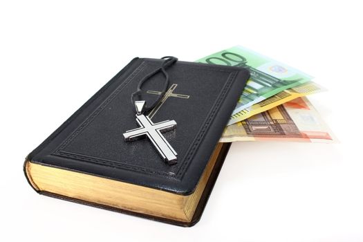 Euro note, song book and cross on a white background