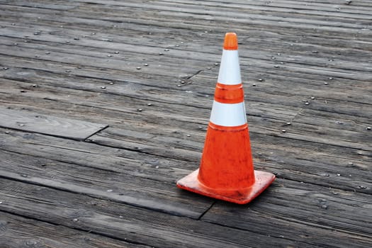 Red orange warning cones on wooden pier